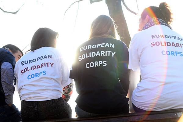 Jóvenes de espaldas con camiseta "cuerpo europeo de solidaridad"